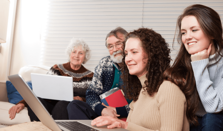 Five steps to get connected to solar PV Two women with brown hair sit in front of a laptop, while an older man and older woman sit behind them