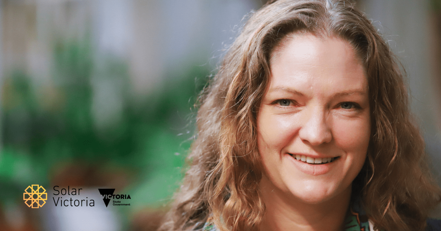 Woman looking at camera smiling, standing in front of cafe
