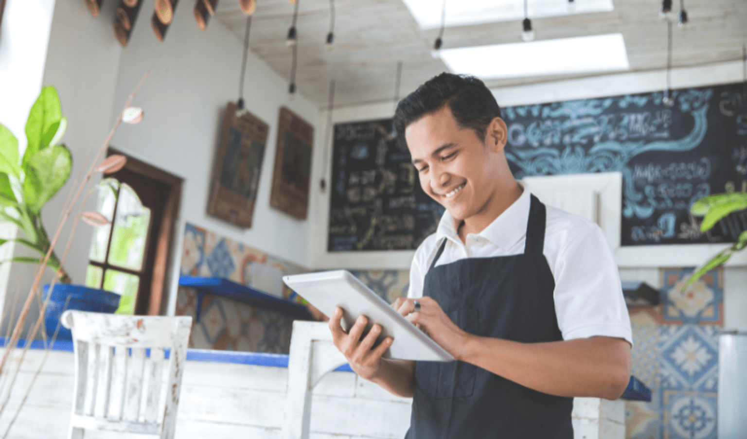 Portrait of young male cafe owner with tablet