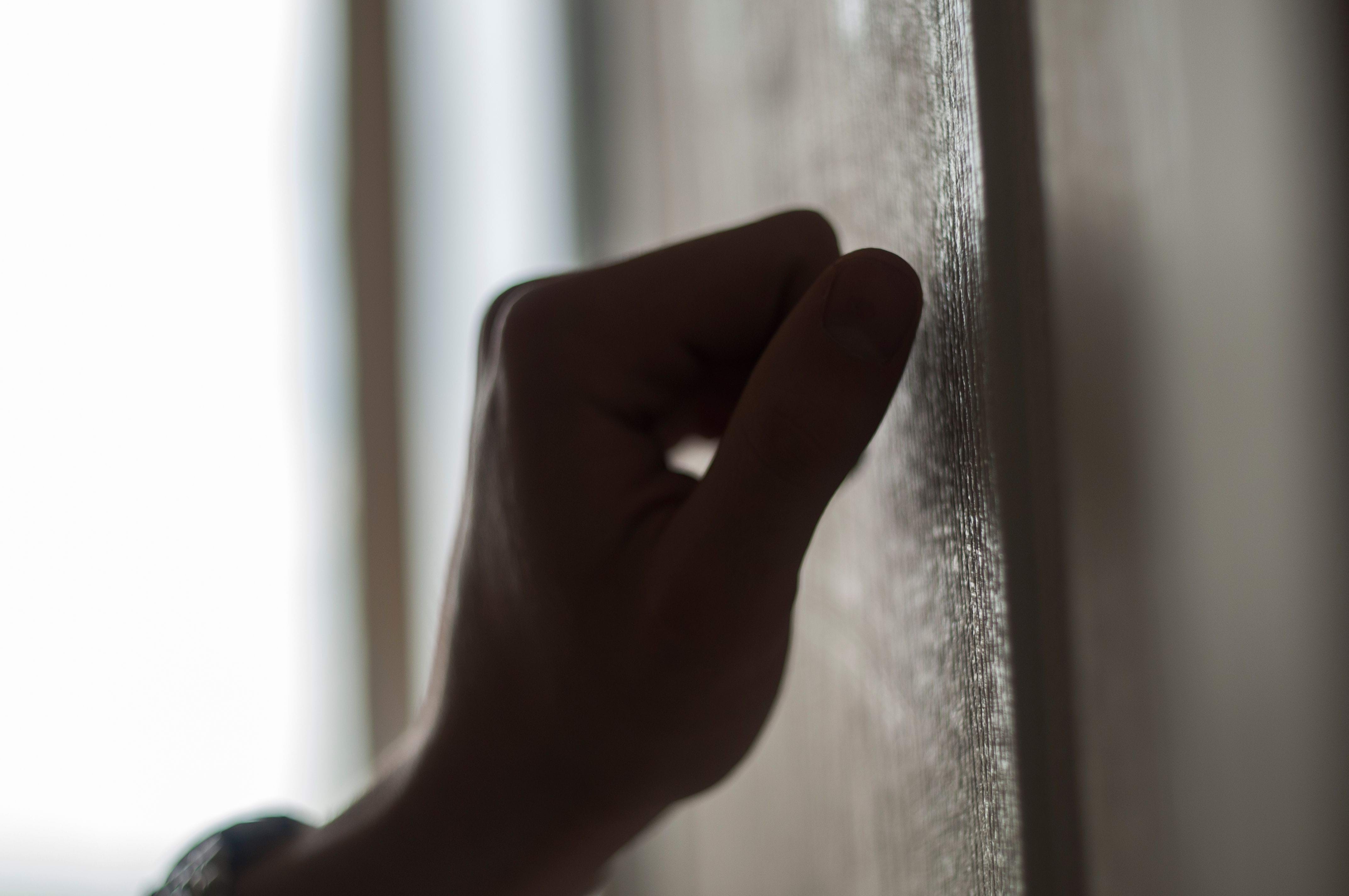 Hand knocking on wooden door