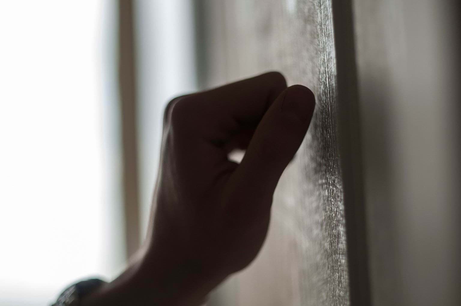 Hand knocking on wooden door