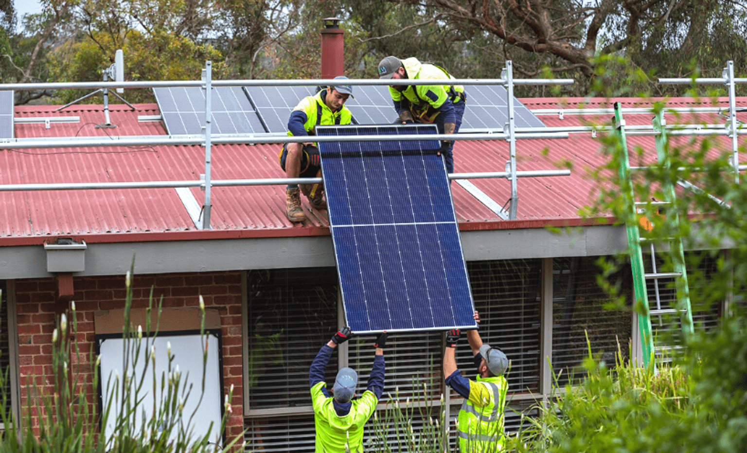 Solar installers installing a solar panel to the roof