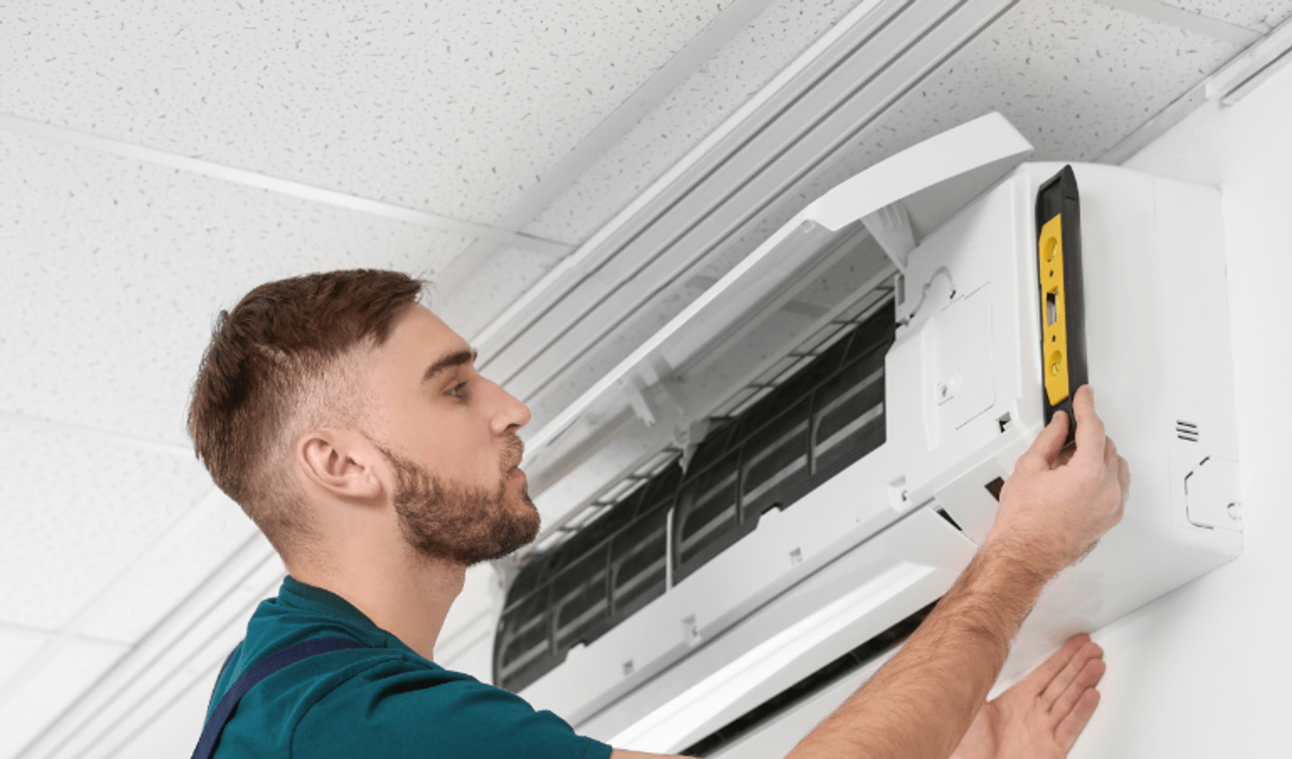 Technician performing maintenance and testing on a split-system air conditioner, demonstrating heat pump installation and energy-efficient climate control skills.