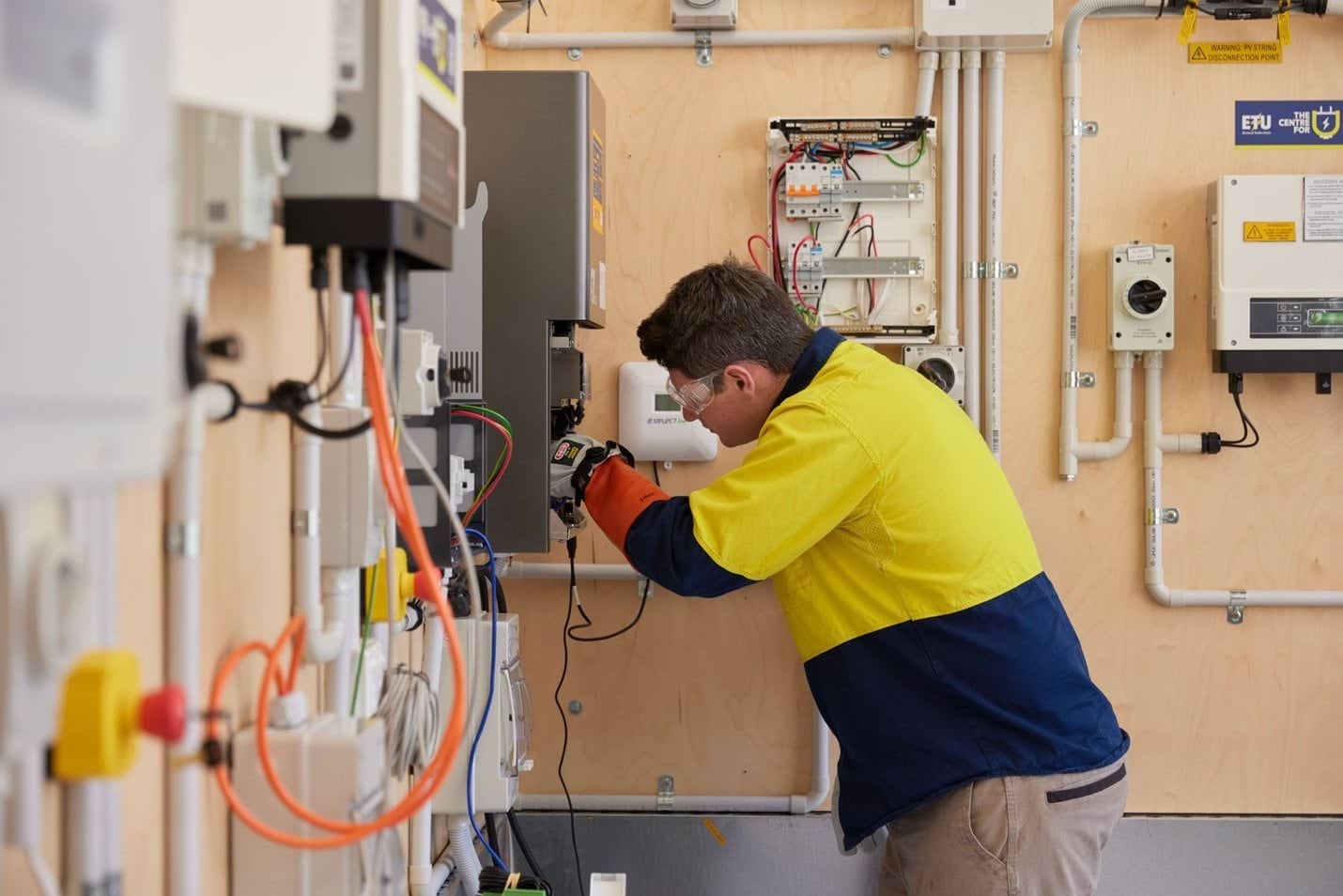 Electrician conducting a switchboard upgrade in a training setting